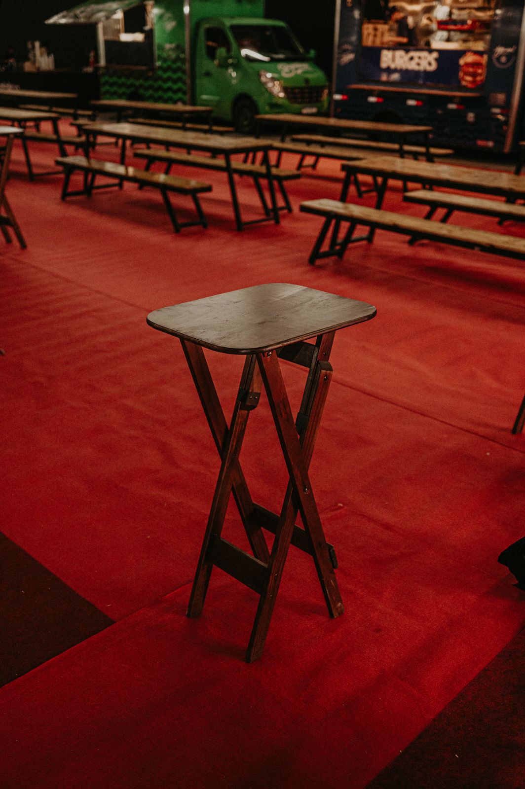 Mesa bistrô de madeira sobre carpete vermelho