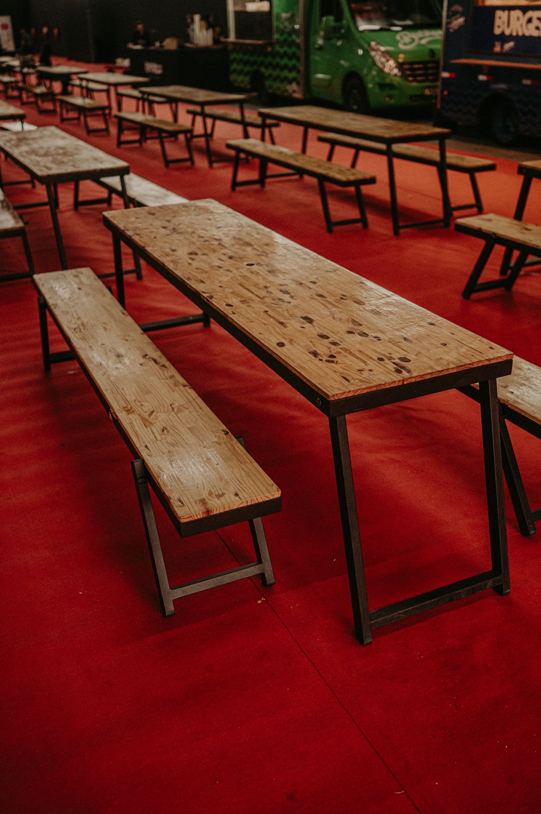 Mesas coletivas alinhadas em galpão de evento