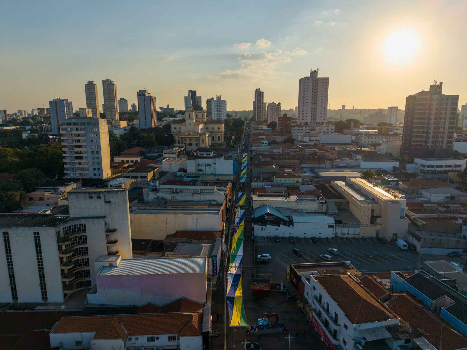 Cidade ao pôr do sol com as velas de tecido coloridas na rua ao fundo