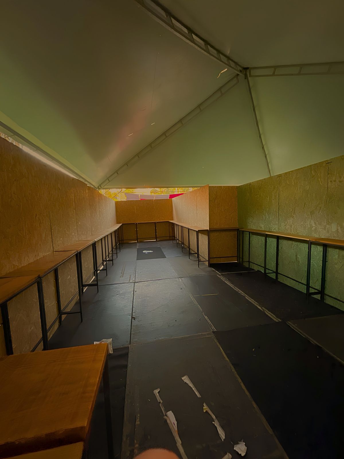 Interior de espaço modular com balcões de madeira e piso preto
