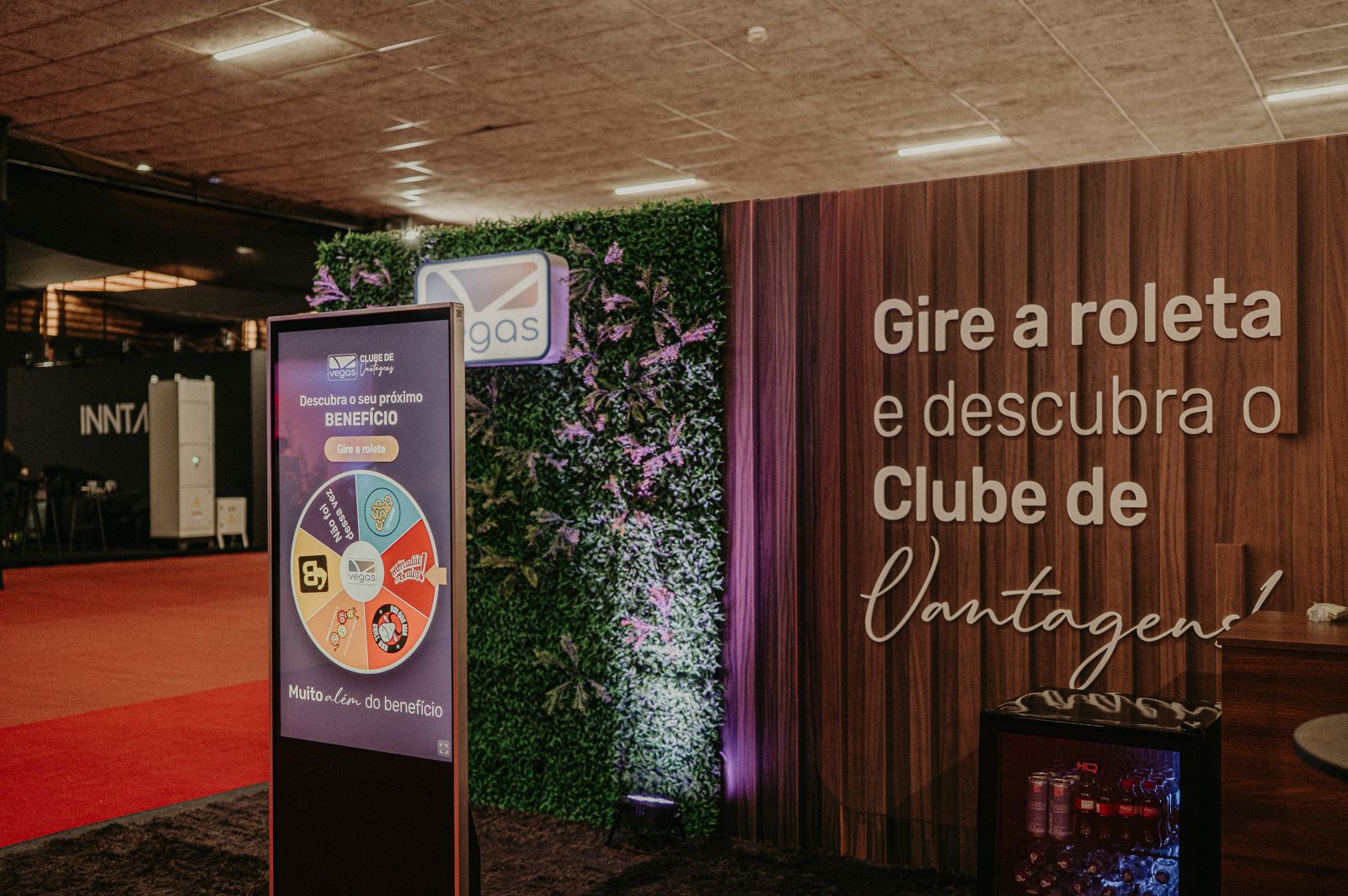 Painel de madeira com roleta digital e jardim vertical em stand promocional